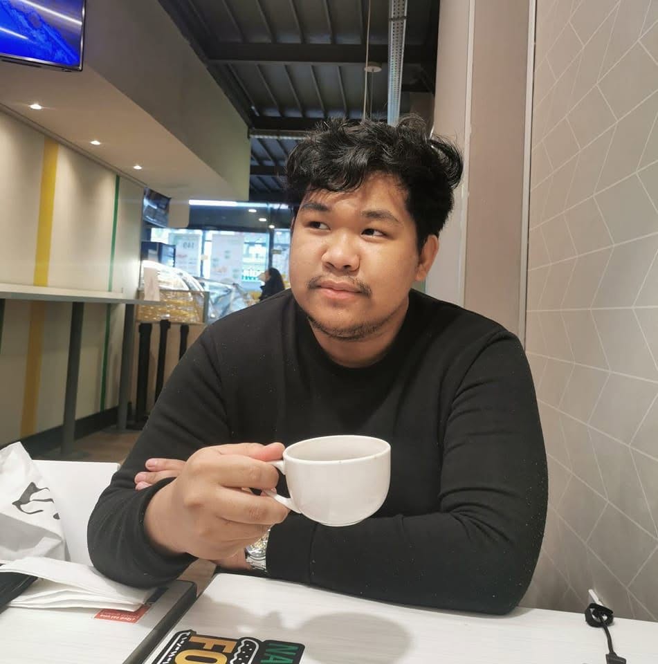 Jesrae, founder of jesrae.dev, holding a coffee cup
